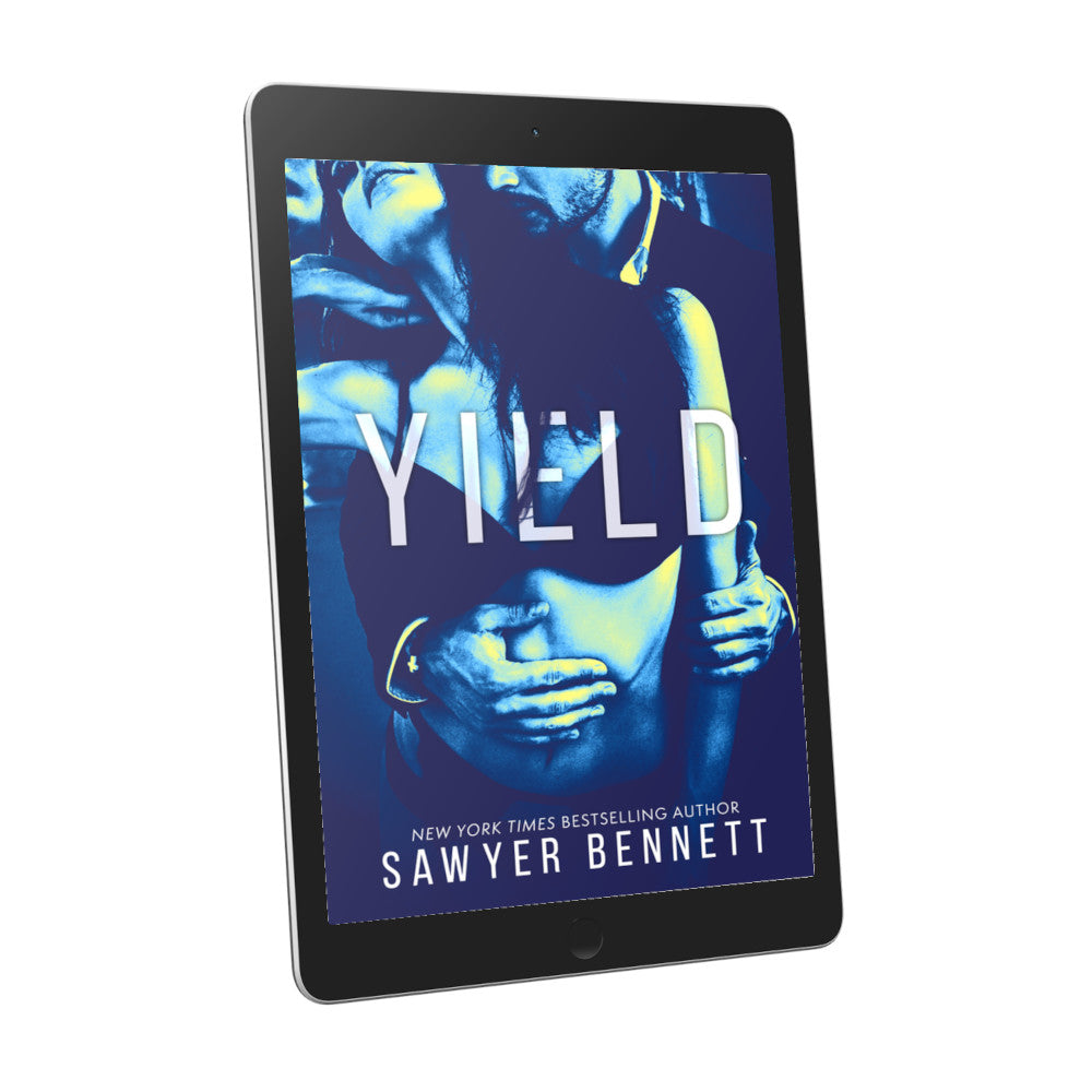 Contemporary romance book cover an attractive man dressed in a suit and a beautiful woman with long dark hair in black lace lingerie. They are embracing one another with a bluish/green color treatment on the photo, displayed on an e-reader. The title of the book is Yield by New York Times Bestselling Author Sawyer Bennett.