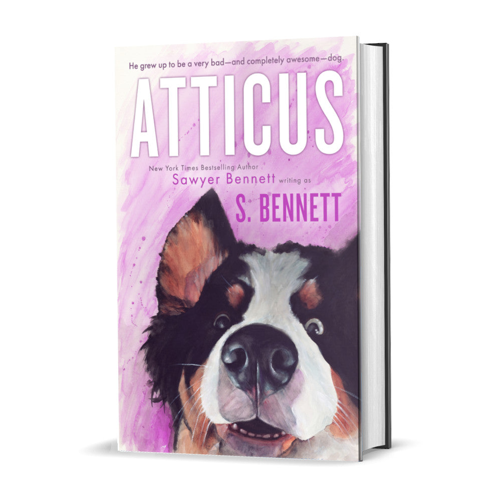 A woman’s fiction hardcover featuring a watercolor painting of a Bernese Mountain Dog’s face. The dog has a slight smile on his face and his eyes are two different colors—one blue and one brown. The title of the book is Atticus by New York Times Bestselling Author Sawyer Bennett.