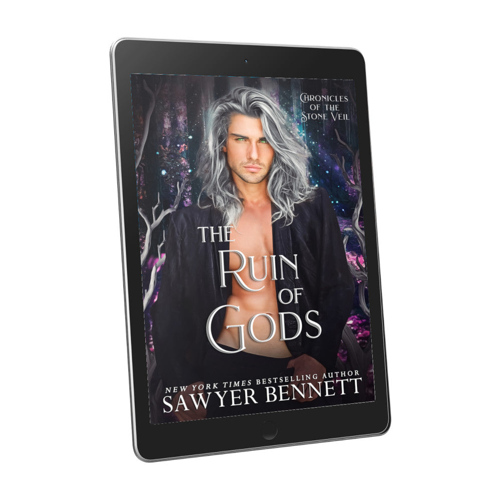 Fantasy romance book cover with a dark background with flecks of pinks, purples and blues and attractive man with long, gray hair wearing a black leather jacket open to reveal a bare chest, displayed on an e-reader. The title of the book is The Ruin of Gods by New York Times Bestselling Author Sawyer Bennett.