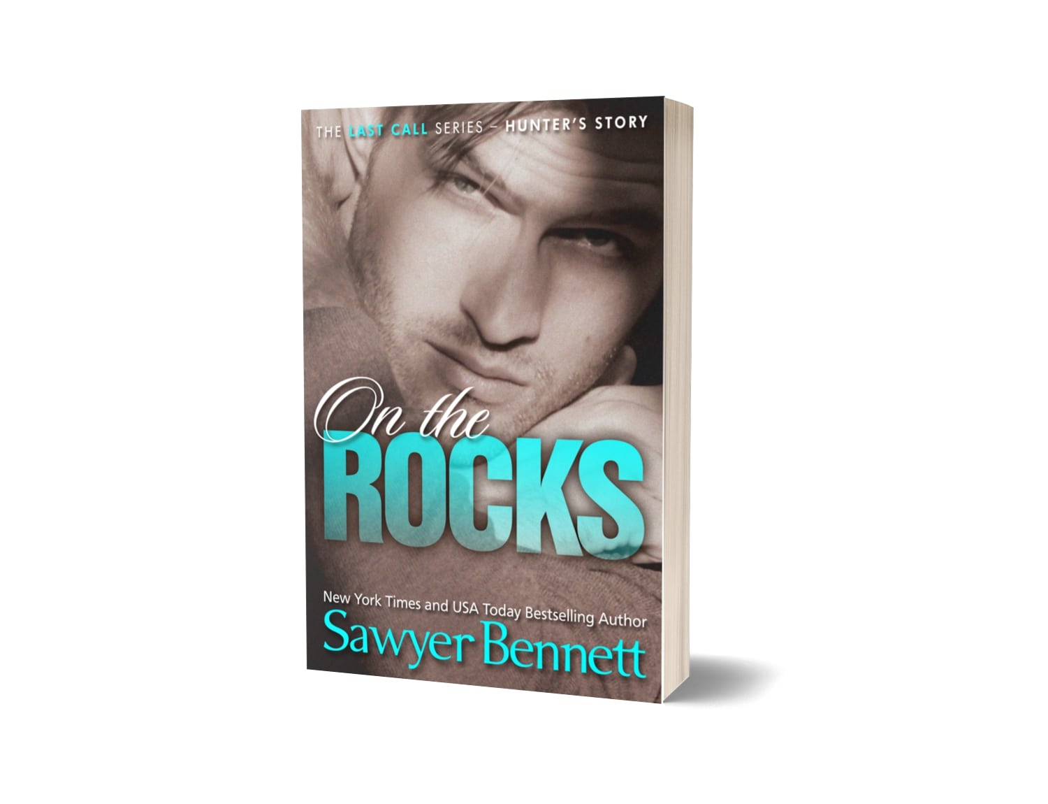 Contemporary romance paperback featuring an attractive man in his early to mid-20’s. The title of the book is On the Rocks by New York Times Bestselling Author Sawyer Bennett.