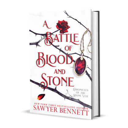 Fantasy romance hardcover with thorned branches sprawled across a white background and blood red amulet hanging from one of the branches. The title of the book is A Battle of Blood and Stone by New York Times Bestselling Author Sawyer Bennett.